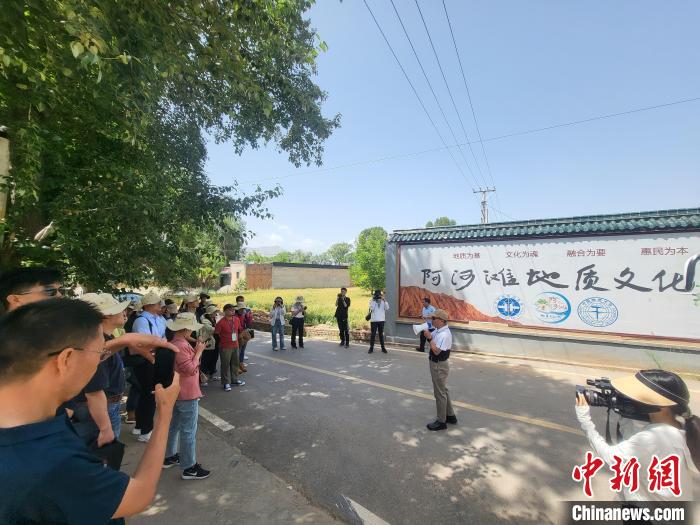 圖為中國地質(zhì)大學(xué)(北京)教授張緒教介紹村落情況?！『衍?攝