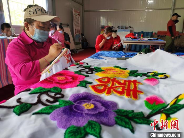 圖為婦女制作青繡?！?zhí)砀?攝