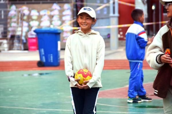 在高原上教孩子們打手球，“慢慢兒來，甭著急！”