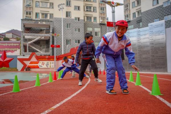 在高原上教孩子們打手球，“慢慢兒來，甭著急！”