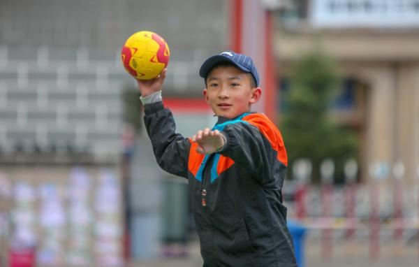 在高原上教孩子們打手球，“慢慢兒來，甭著急！”