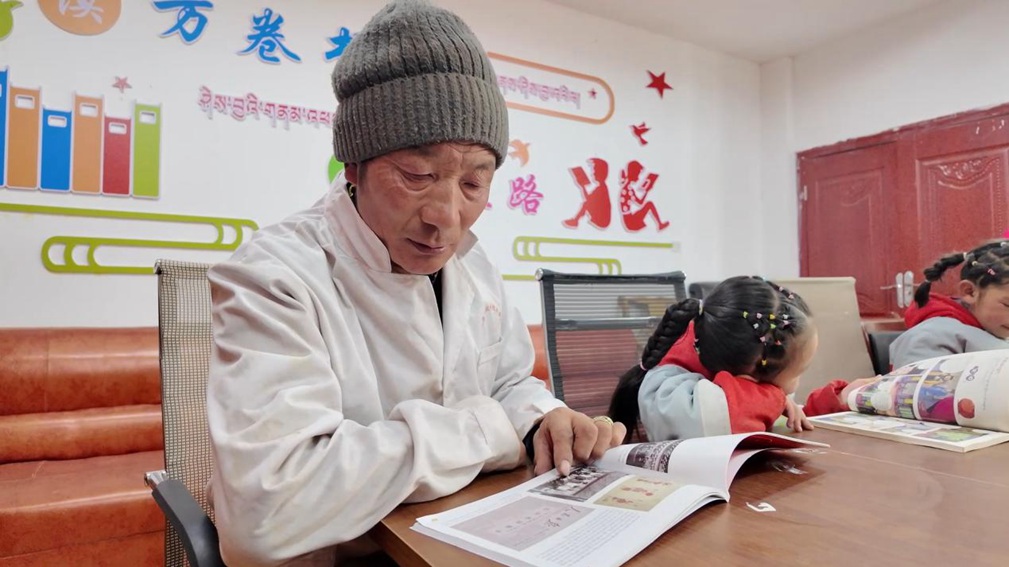 一位當(dāng)?shù)卮迕窈秃⒆觽冊谀良視堇锉M情享受閱讀時光。申扎縣融媒體中心供圖