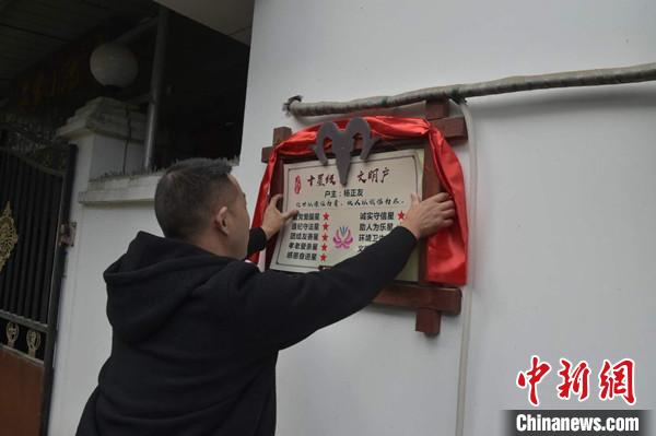 桂溪鎮(zhèn)渭溝村政府工作人員為“十星級(jí)文明戶”掛上牌匾?！钣?攝