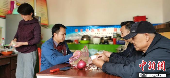 圖為扶貧路上“臨時一家人”準(zhǔn)備午餐?！∥航ㄜ?攝