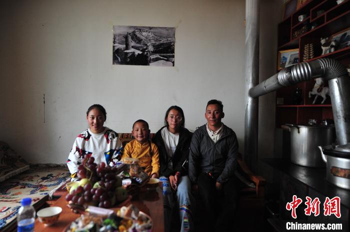 圖為8月12日，2018年7月從距那曲市色尼區(qū)城區(qū)那曲鎮(zhèn)90千米外的古露鎮(zhèn)當(dāng)桑村搬遷至城區(qū)的旦增(右一)與家人在80多平方米的新家合影(資料圖)?！垈?攝