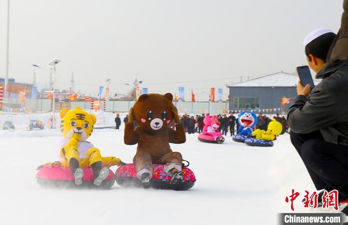 圖為臨夏市南龍鎮(zhèn)馬家莊村舉辦的鄉(xiāng)村文化旅游節(jié)上，游客穿著卡通服裝在體驗雪上飛碟項目。近年來，臨夏州形成了“春賞花、夏避暑、秋摘果、冬玩雪”的全季節(jié)旅游產(chǎn)品體系。(資料圖) 高展 攝