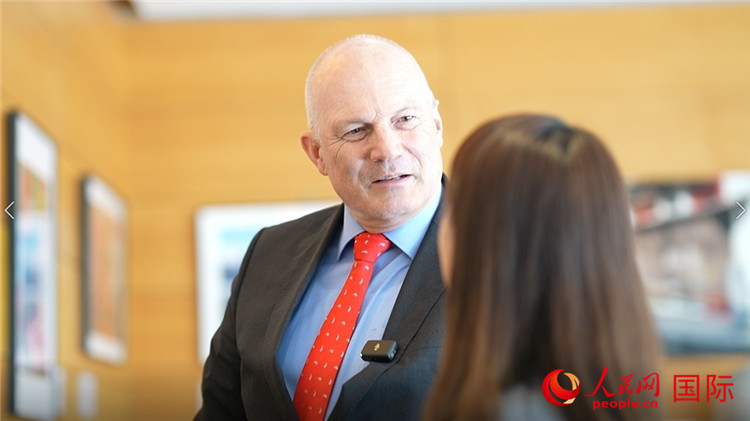 瑞士駐華大使白瑞誼介紹使館內(nèi)陳列的照片。人民網(wǎng) 彭昱凱攝