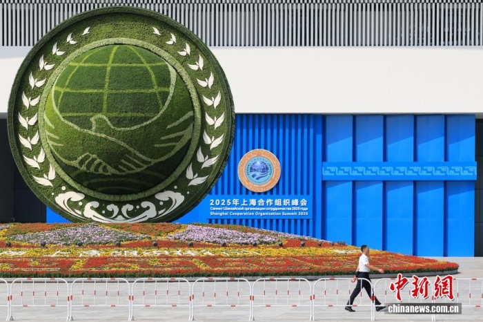8月31日，天津，一名工作人員從2025年上海合作組織峰會(huì)主會(huì)場(chǎng)外的景觀花壇旁經(jīng)過(guò)。當(dāng)日，2025年上海合作組織峰會(huì)在天津舉行。<a target='_blank' href='/'><p  align=