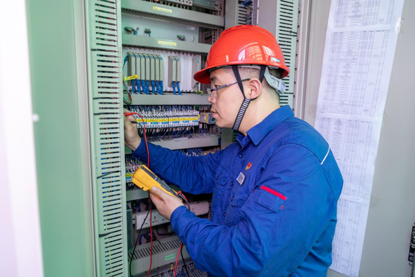 呂曉勇在保護(hù)盤柜前檢查二次回路接線情況。受訪者供圖