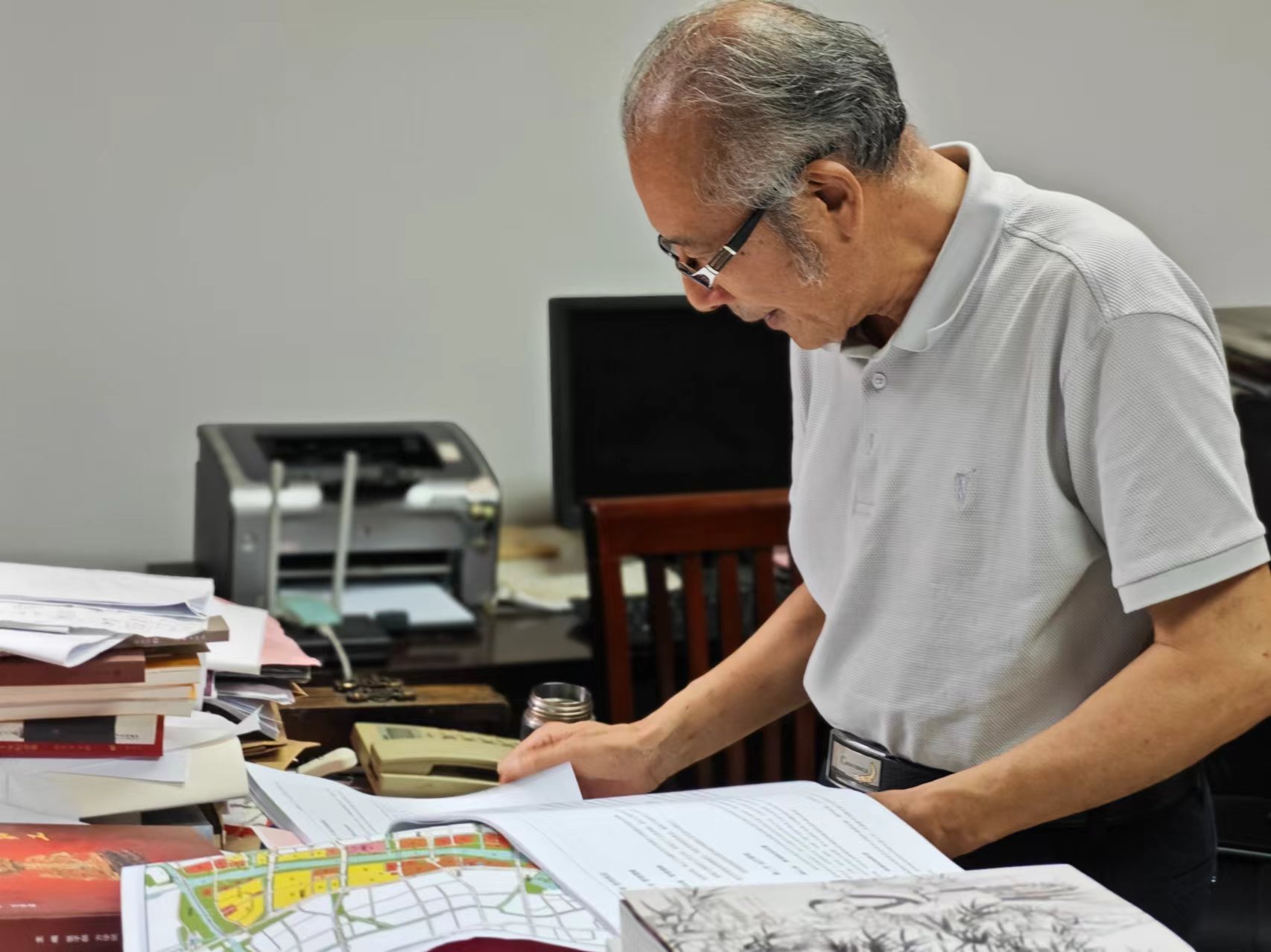 顧風在辦公室翻閱資料。人民網(wǎng)記者 黃鈺攝