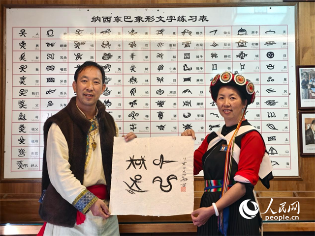 人民網(wǎng)“行進中國”云南調(diào)研采訪團走進麗江，和閏元現(xiàn)場用東巴文寫下“行進中國”。人民網(wǎng)記者 符皓攝