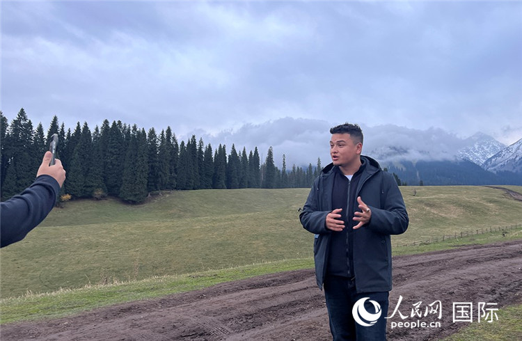 在庫爾德寧，吾買爾江被雪山美景震撼，即興錄制了短視頻作品。人民網(wǎng)記者曾書柔攝