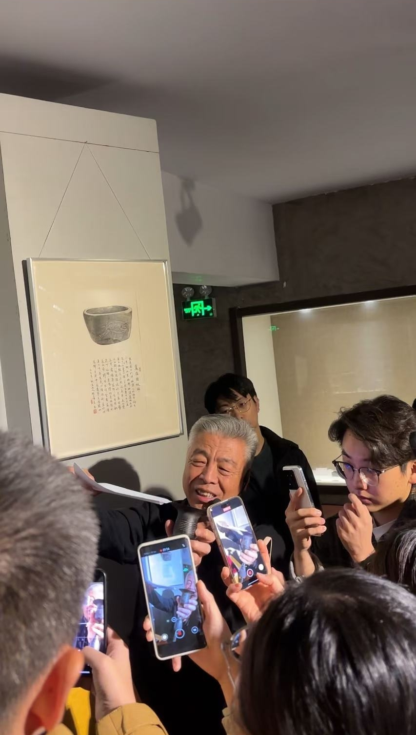 黑陶邢文化博物館館長邢葆東展示兩張相疊的A4紙，向記者解釋此為杯口的厚度。