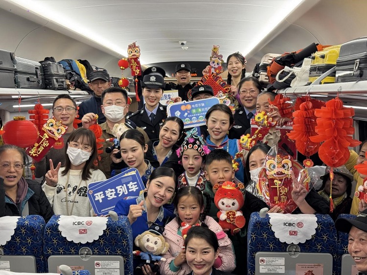 春節(jié)期間，在中老鐵路磨萬（磨丁—萬象）段，鐵路客運員工與乘客合影留念。李加勇攝