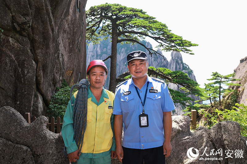 全國(guó)道德模范李培生（左）和胡曉春在迎客松前合影。人民網(wǎng)記者 張俊攝