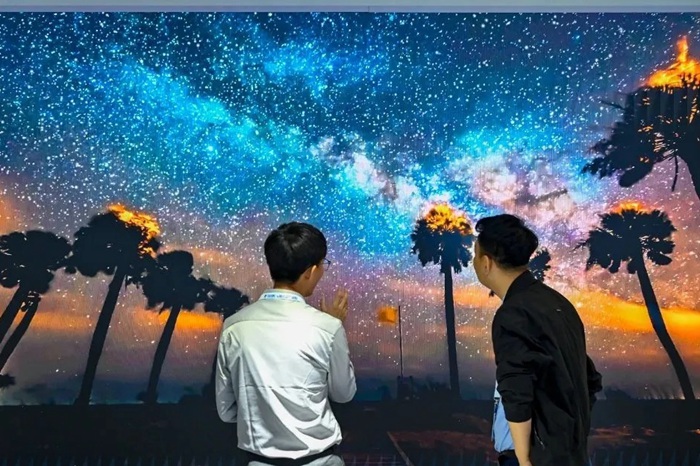 長春光博會希達(dá)電子展區(qū)，一位工作人員正在給一位觀眾講解。（長春新區(qū)供圖）