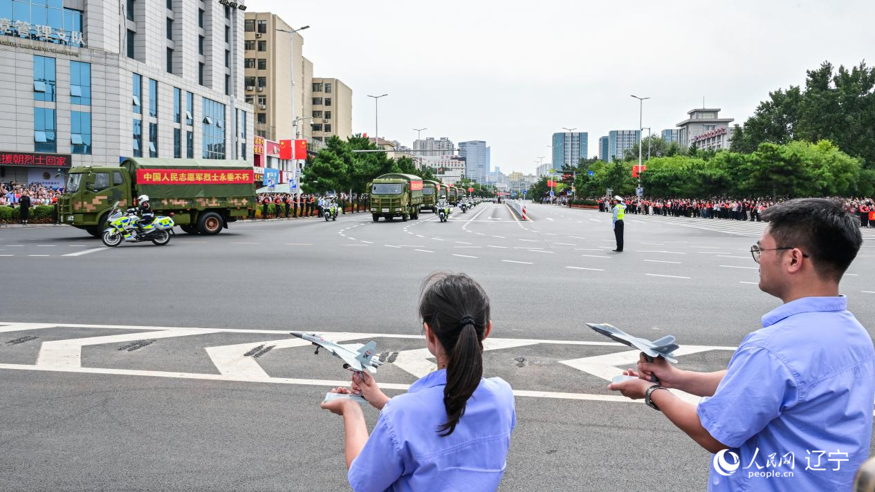 航空工業(yè)沈飛的青年技術(shù)人員拿著受閱戰(zhàn)機的模型迎接烈士遺骸。航空工業(yè)沈飛供圖