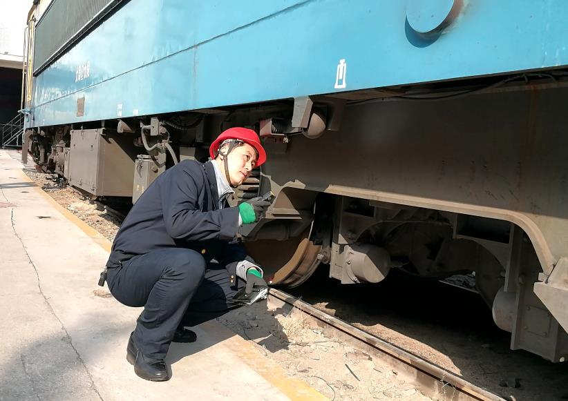 韓文盛全神貫注檢查機(jī)車走行部。