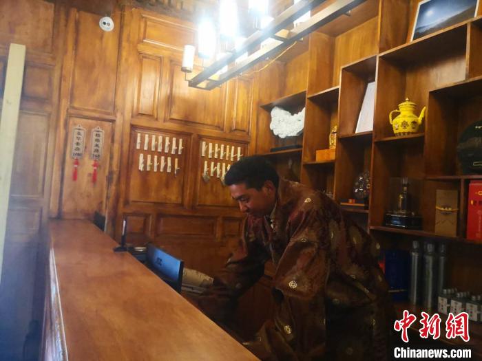 圖為桑杰才讓用電腦處理財務(wù)?！∈缝o靜 攝