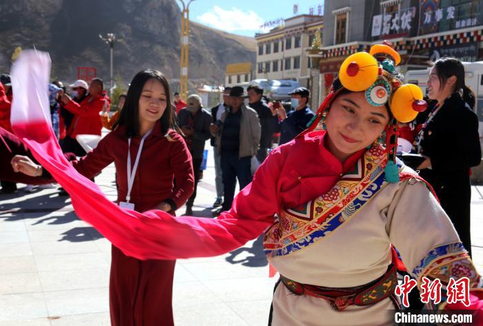 圖為中外記者向當(dāng)?shù)孛癖妼W(xué)習(xí)民族歌舞文化?！?zhí)砀?攝