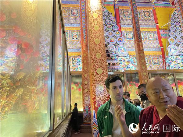 7月25日，省級非物質(zhì)文化遺產(chǎn)項目塔爾寺酥油花的代表性傳承人朋措堅參（右）在塔爾寺酥油花館講解酥油花的制作過程。人民網(wǎng) 謝瑩攝