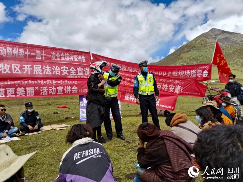 給牧民講如何佩戴安全頭盔。巴登攝