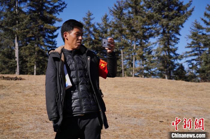 圖為桑杰加進(jìn)行巡查并拍照記錄?！●R銘言 攝