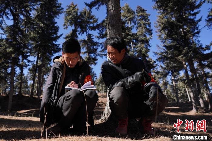 圖為桑杰加(左)和同事記錄巡查結(jié)果?！●R銘言 攝