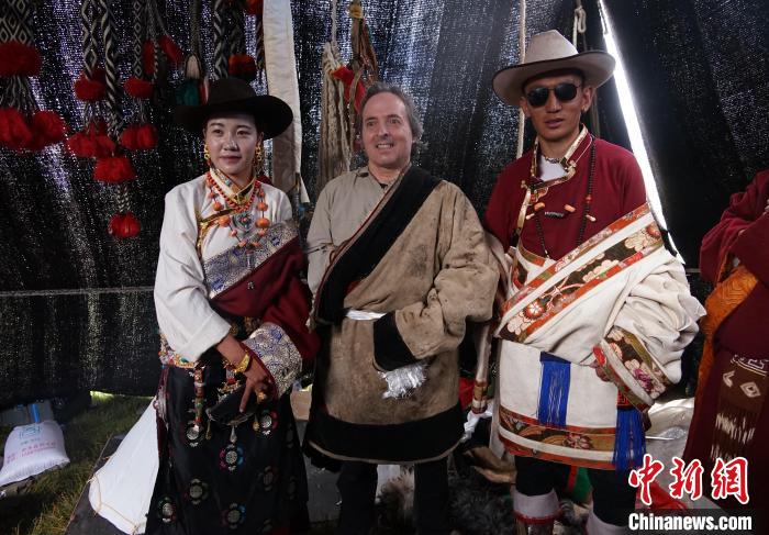 圖為一名外籍?dāng)z影師(中)身穿藏服和藏族民眾合影留念?！●R銘言 攝