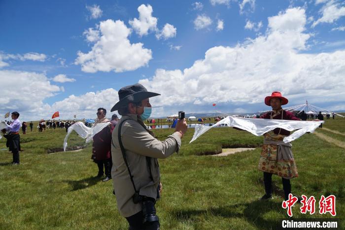 圖為一名外籍?dāng)z影師記錄當(dāng)?shù)夭刈鍤g迎儀式?！●R銘言 攝