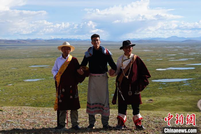 圖為一名留學(xué)生身穿自己國家的服飾和藏族民眾合影留念。　馬銘言 攝