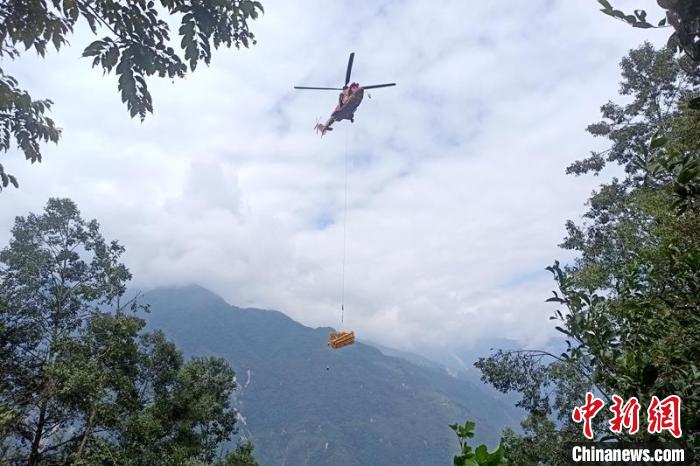 直升機起飛將搶修塔材運往海拔1950米的110千伏唐下線29號塔位?！⌒鞈c明 攝