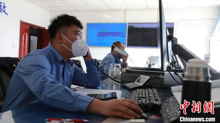 圖為貨運調(diào)度人員與外勤工作人員聯(lián)系掌握車輛裝載情況?！±钌?攝