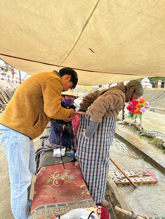 扎西奪爾登為路邊老人送去保暖圍腰。阿壩州文明辦供圖