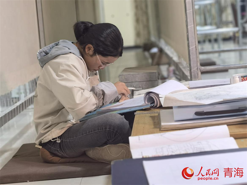 正在學(xué)習(xí)畫底稿的尕讓旺姆。人民網(wǎng) 陳明菊攝