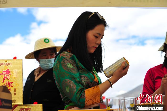 圖為拉薩市民在特色農(nóng)畜產(chǎn)品展示展銷會上選購商品?！垈?攝