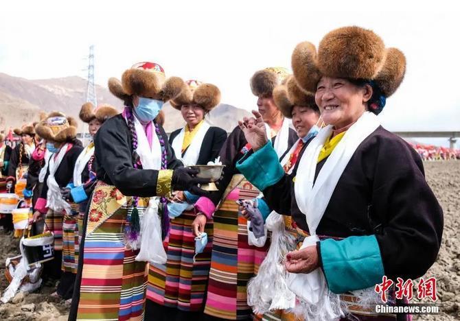 資料圖：西藏自治區(qū)拉薩市曲水縣才納鄉(xiāng)協(xié)榮村參加春耕儀式的村民互敬青稞酒。按照傳統(tǒng)，當?shù)卮迕裆碇?jié)日盛裝，舉行隆重的儀式，祈福一年的豐收。<a target='_blank' ><p  align=