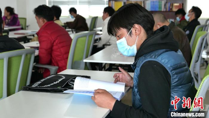 圖為正在閱讀“杰松達(dá)孜”藏歷法教材的學(xué)員。　謝牧 攝