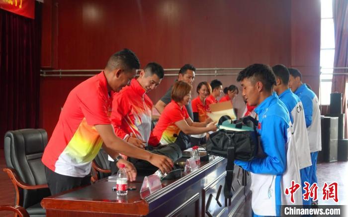 圖為世界冠軍們?yōu)槲鞑刈灾螀^(qū)體校的學(xué)生們送上暖心物資。　冉文娟 攝