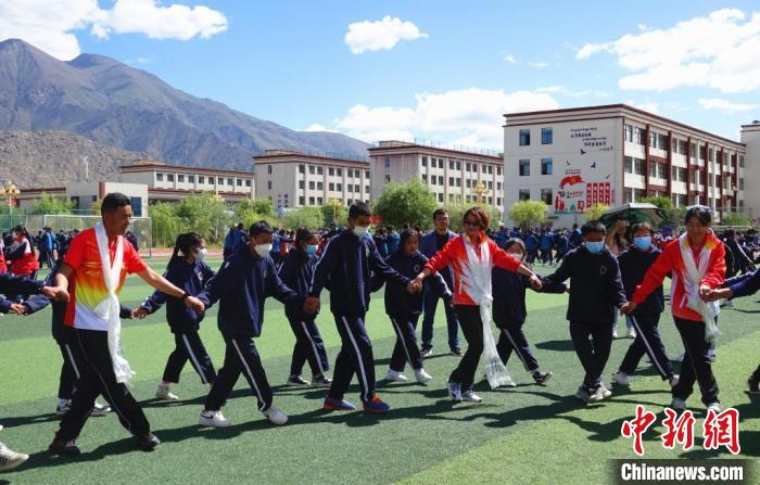 圖為世界冠軍與拉薩阿里地區(qū)高級(jí)中學(xué)學(xué)生一起跳鍋莊?！∪轿木?攝