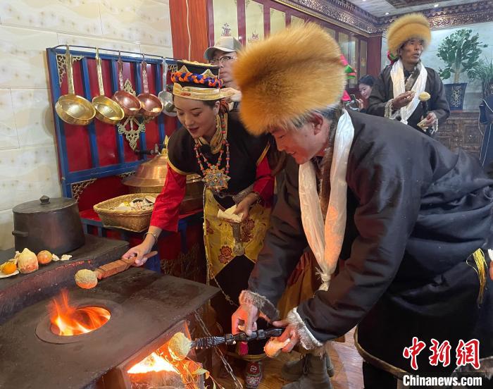 圖為人們在火上烤節(jié)日美食“結(jié)達(dá)”。　冉文娟 攝