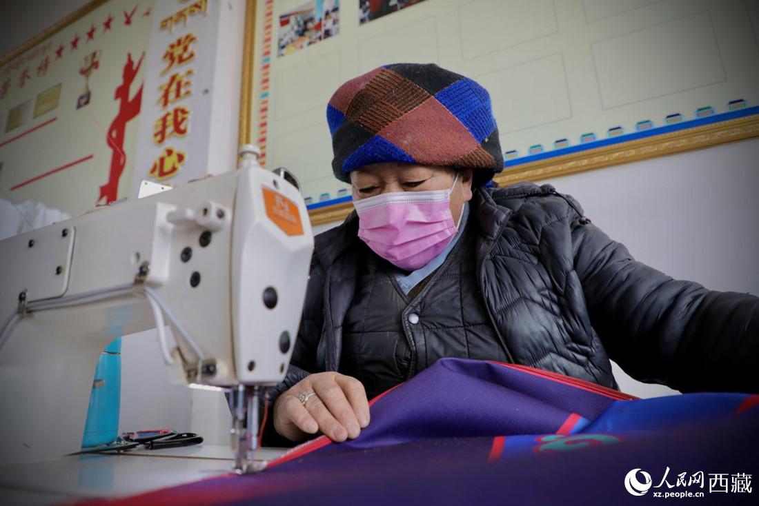 農(nóng)牧民專業(yè)合作社里的村民正在制作門簾。人民網(wǎng) 次仁羅布攝