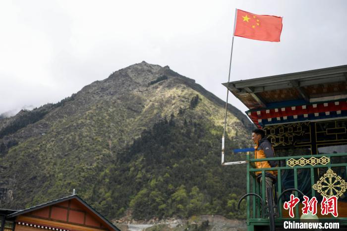 村民站在樓房上觀望?！钊A峰 攝