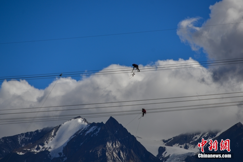資料圖為2020年6月23日，西藏阿里聯(lián)網(wǎng)工程施工人員在日喀則希夏邦馬雪山附近進(jìn)行走線作業(yè)，安裝絕緣設(shè)備。 <a target='_blank' href='/'><p  align=