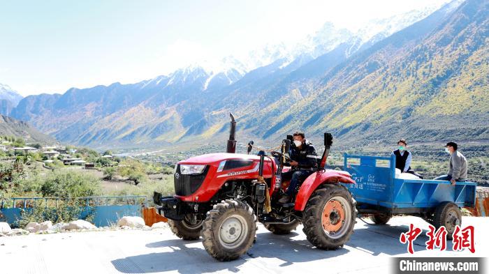 圖為工作人員將把加工完成的糌粑運(yùn)送至村民手中?！〖卫杩h融媒體中心供圖