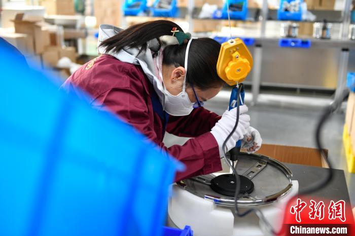 圖為工人正在組裝炊具。　貢嘎來(lái)松 攝