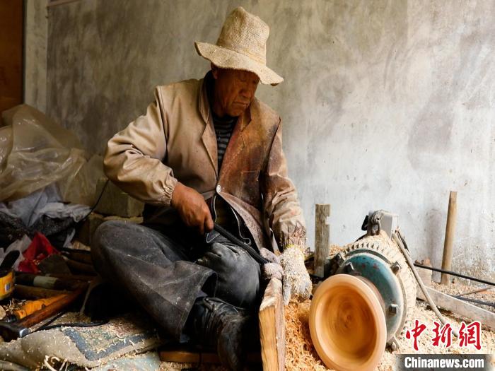 圖為手工藝人正在制作木碗。　 鄧海平 攝