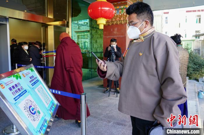 圖為政協(xié)委員掃場(chǎng)所碼進(jìn)入會(huì)場(chǎng)。　江飛波 攝