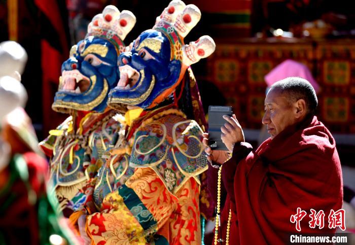 2月19日，正在拍攝跳神活動(dòng)的僧人?！±盍?攝