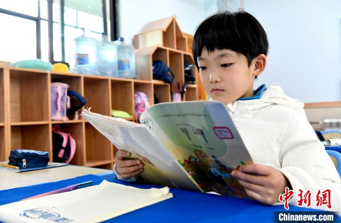 3月14日，西藏拉薩市第一小學(xué)一年級(jí)六班學(xué)生丁增樂(lè)吉在閱讀藏語(yǔ)課本?！±盍?攝